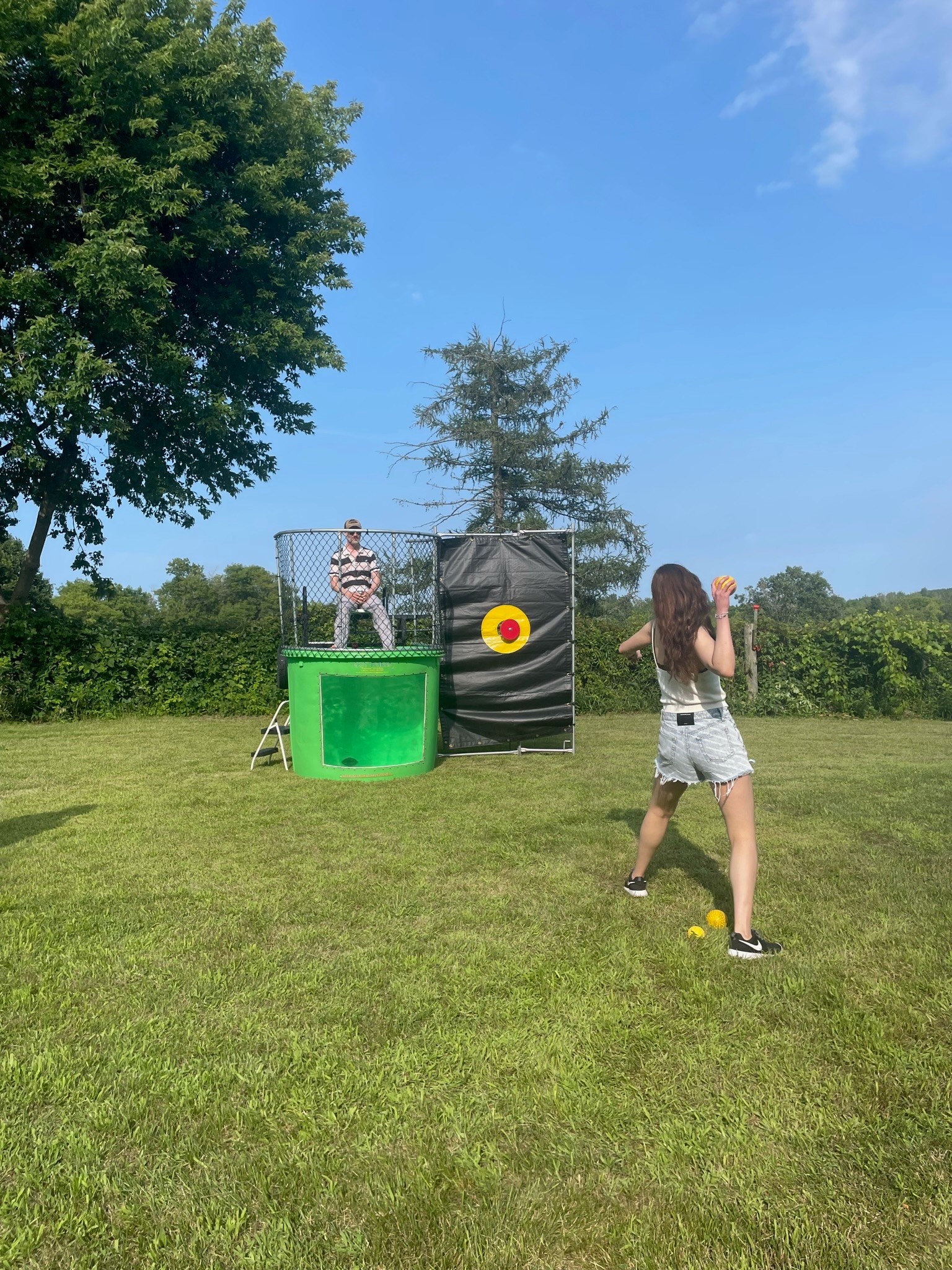 Managing Director Rob Fedrock sits on the dunk tank ledge while an Analyst takes aim to try to dunk him in.